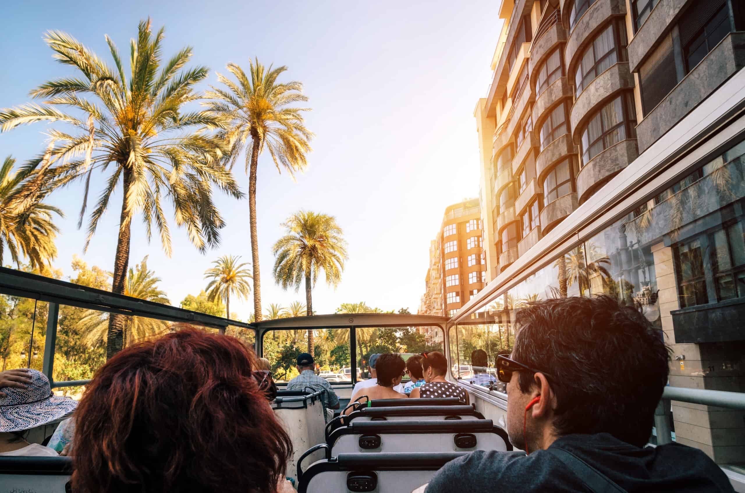 Tourists on open top sightseeing bus in city